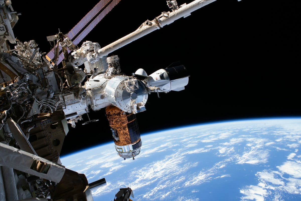 国際宇宙ステーションに係留中の宇宙船「クルー・ドラゴン」（中央右）。中央下に見えているのは宇宙ステーション補給機「こうのとり」9号機