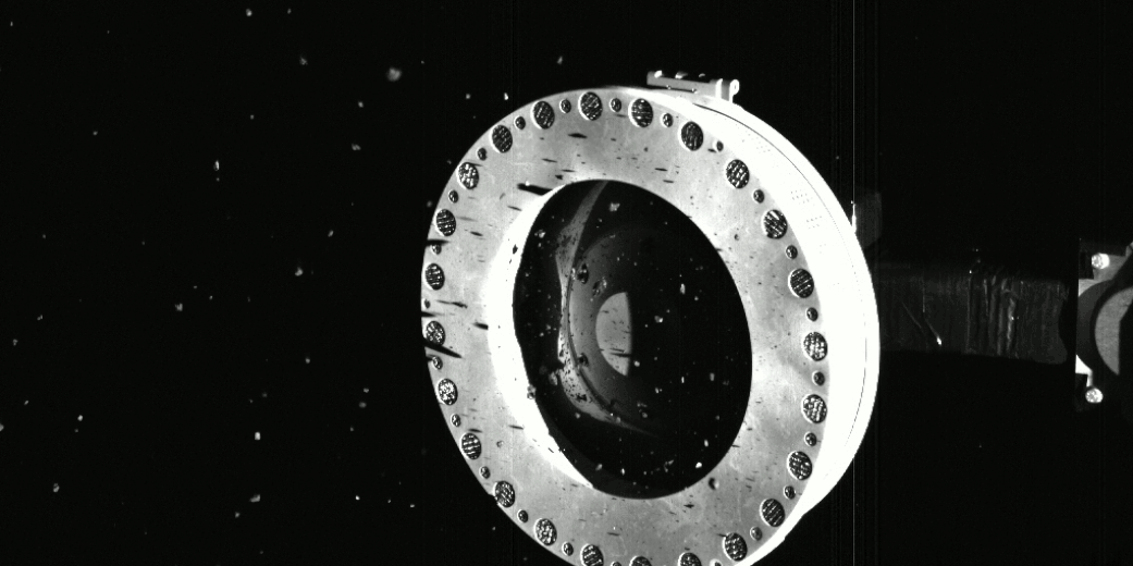 オシリス・レックスのサンプル採取装置「TAGSAM」の先端を写した連続画像。漂っているのは採取された粒子の一部とみられている（Credit: NASA）