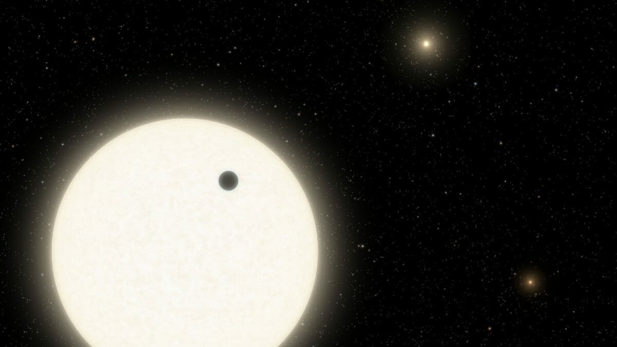 恒星「KOI-5A」（左下）の手前を横切る系外惑星「KOI-5Ab」を描いた想像図。右上と右下には3連星を成す別の恒星も描かれている（Credit: Caltech/R. Hurt (IPAC)）