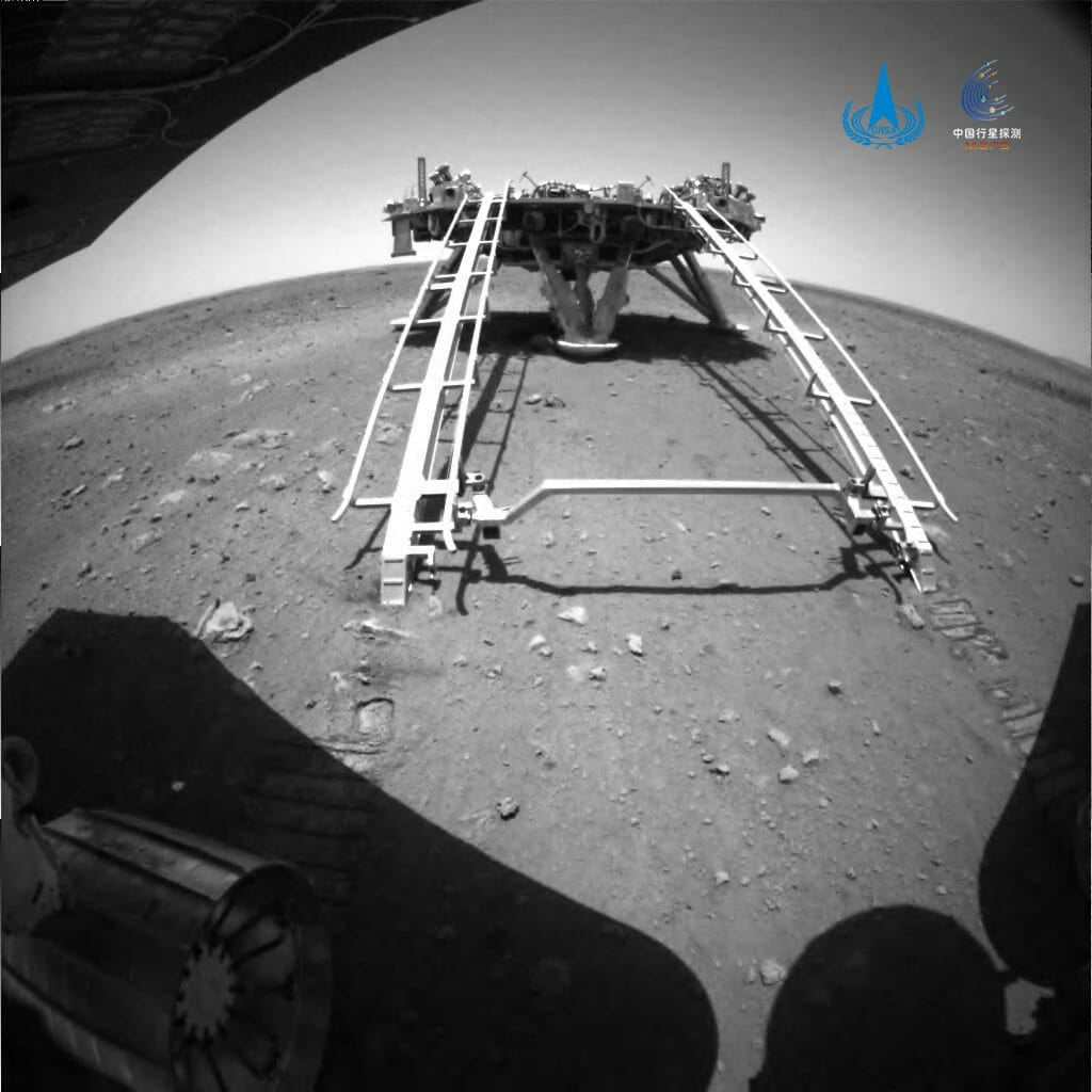 中国の火星探査車「祝融」の障害物回避カメラによって撮影された画像。着陸機のスロープから続く走行痕が見えている（Credit: CNSA）