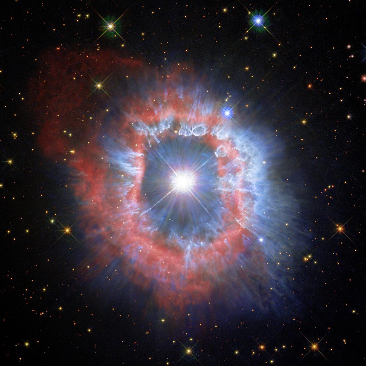 りゅうこつ座AG星と周囲に広がる星雲。赤はイオン化した水素・窒素ガス、青は塵の分布に対応する（Credit: ESA/Hubble and NASA, A. Nota, C. Britt）