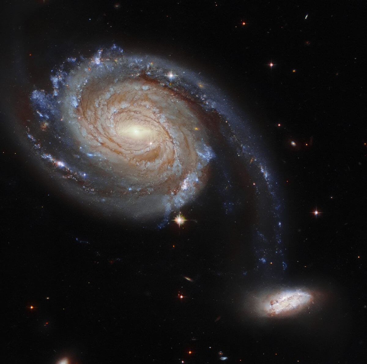 美しき渦巻銀河に導かれる小さな銀河の運命。相互作用銀河「Arp 86