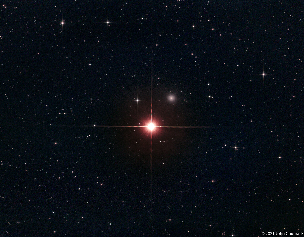 アンドロメダ座β星「ミラク」と、その右上に見えている楕円銀河NGC404（通称「ミラクの幽霊」）（Credit: John Chumack）