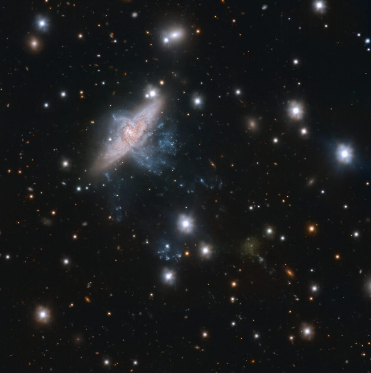 重なって見える渦巻銀河「NGC 3314a」「NGC 3314b」（左上）と、UDG（超淡銀河、超拡散状銀河）に分類される銀河「UDG 32」（右下）（Credit: ESO/Iodice et al.）