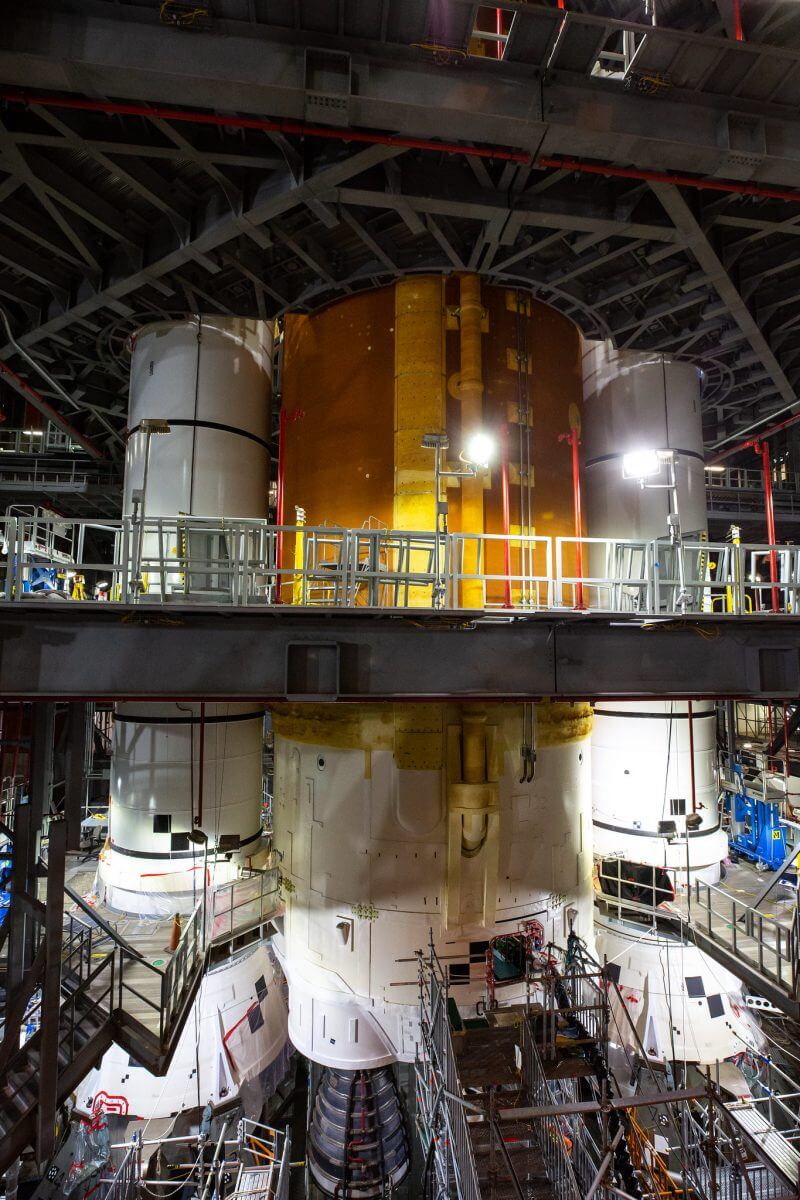 ケネディ宇宙センターのロケット組立棟（VAB）で打ち上げ前のテストと準備が進められているSLS（スペースローンチシステム）。4基のRS-25エンジンを搭載したコアステージと固体燃料ロケットブースターの下部が写っている（Credit: NASA/Corey Houston）