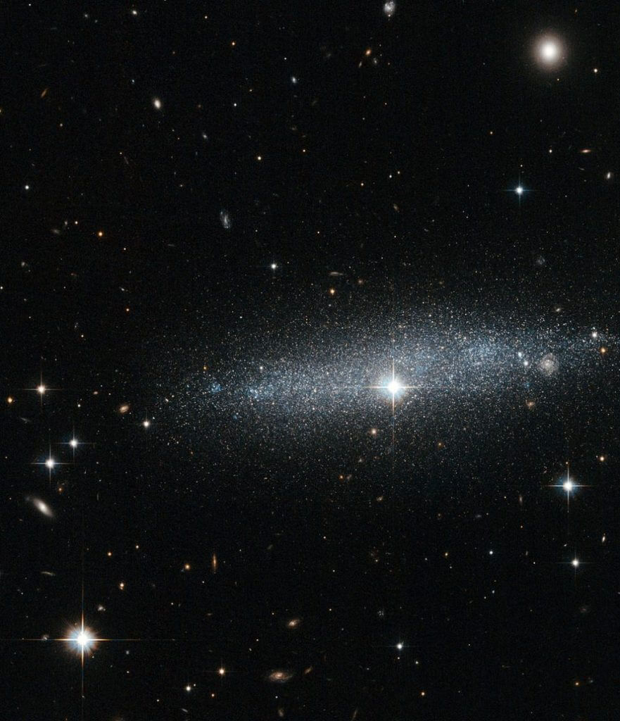 【▲ハッブル宇宙望遠鏡が2012年に撮影した「ESO318-13」。ESO 318-13の右端付近に見えているのは遠方の渦巻銀河（Credit: NASA/ESA/Hubble）】
