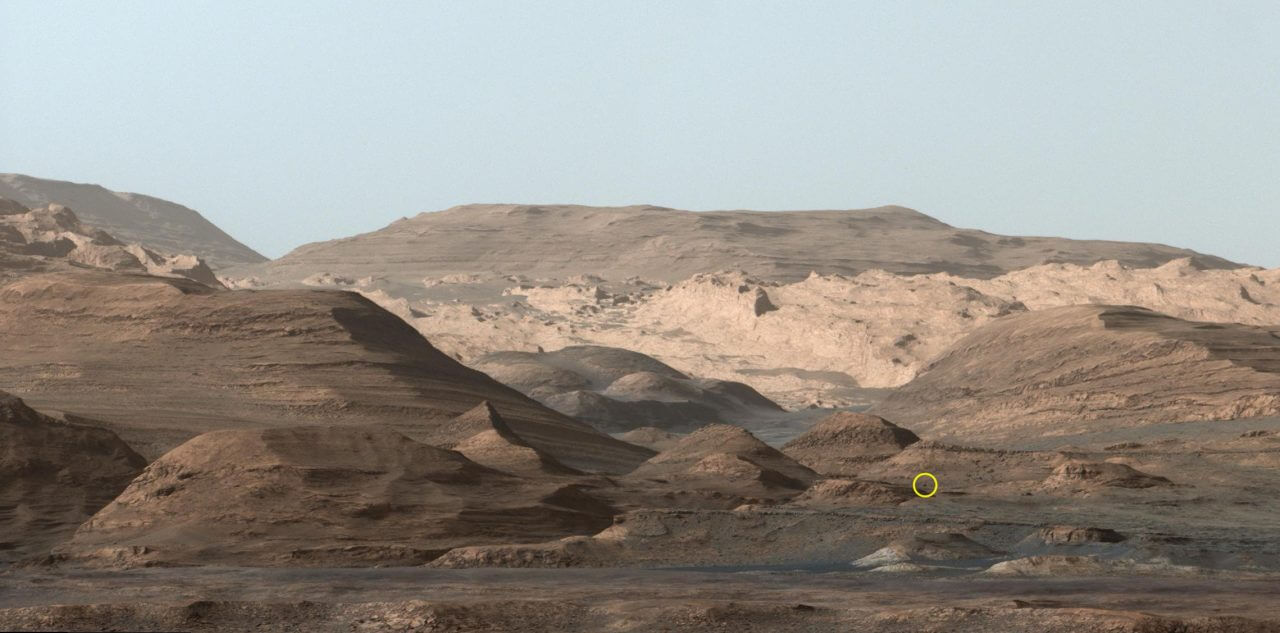 【▲ キュリオシティのMastcamを使って2015年9月9日に撮影されたアイオリス山。黄色い丸の中に見える小さな黒い点は、7年後の2022年7月15日にキュリオシティが間近で撮影することになる岩（Credit: NASA/JPL-Caltech）】