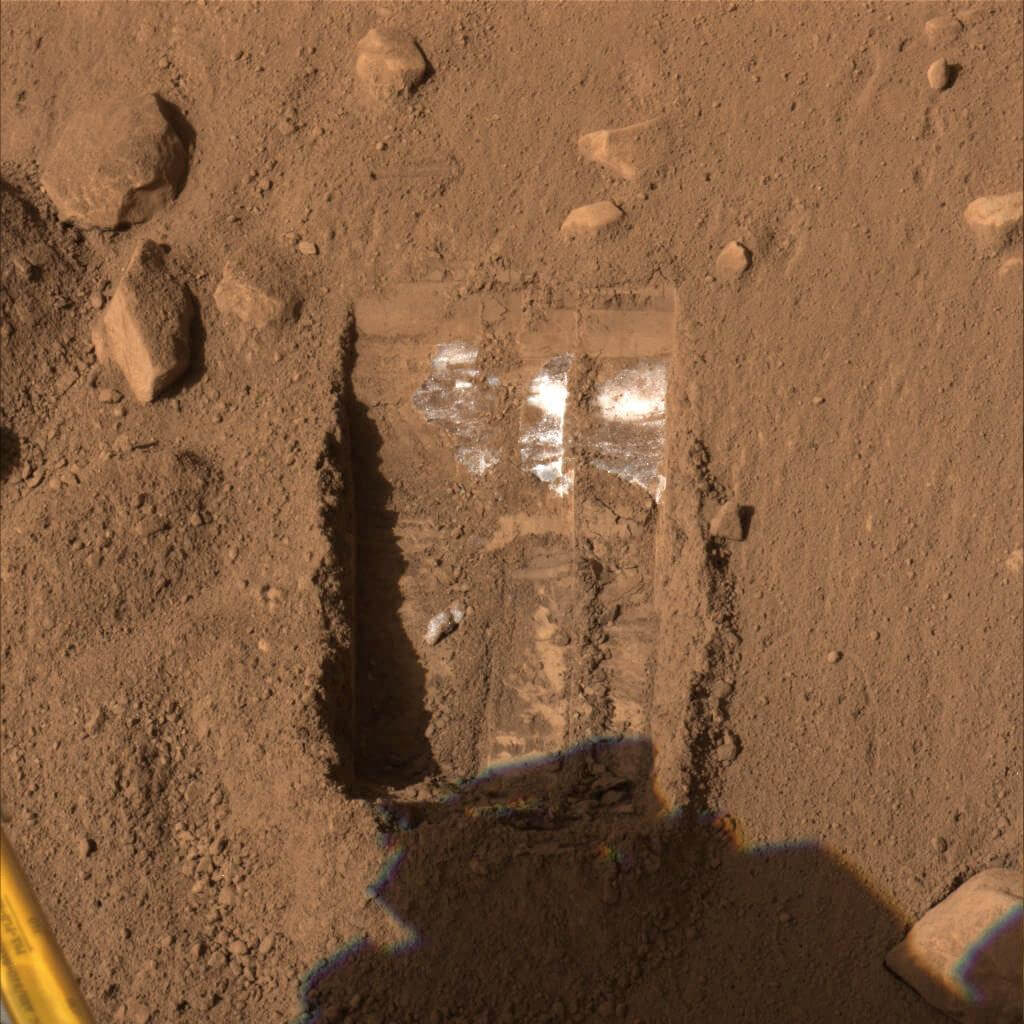 【▲ NASAの火星探査機「フェニックス」がロボットアームで地表を掘ったところ、深さ7～8cmのところに水の氷とみられる物質が見つかった。2008年6月撮影（Credit: NASA/JPL-Caltech/University of Arizona/Texas A&M University）】