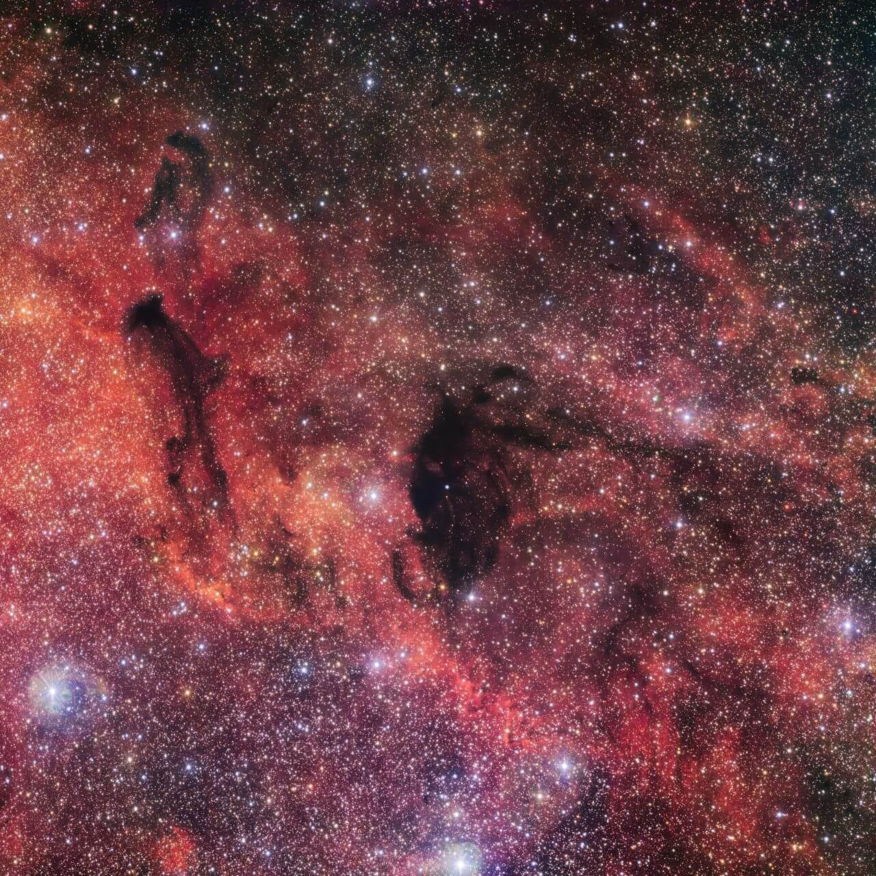 【▲ 暗黒星雲「バーナード92」（中央）と「バーナード93」（左）（Credit: ESO/VPHAS+ team. Acknowledgement: Cambridge Astronomical Survey Unit）】