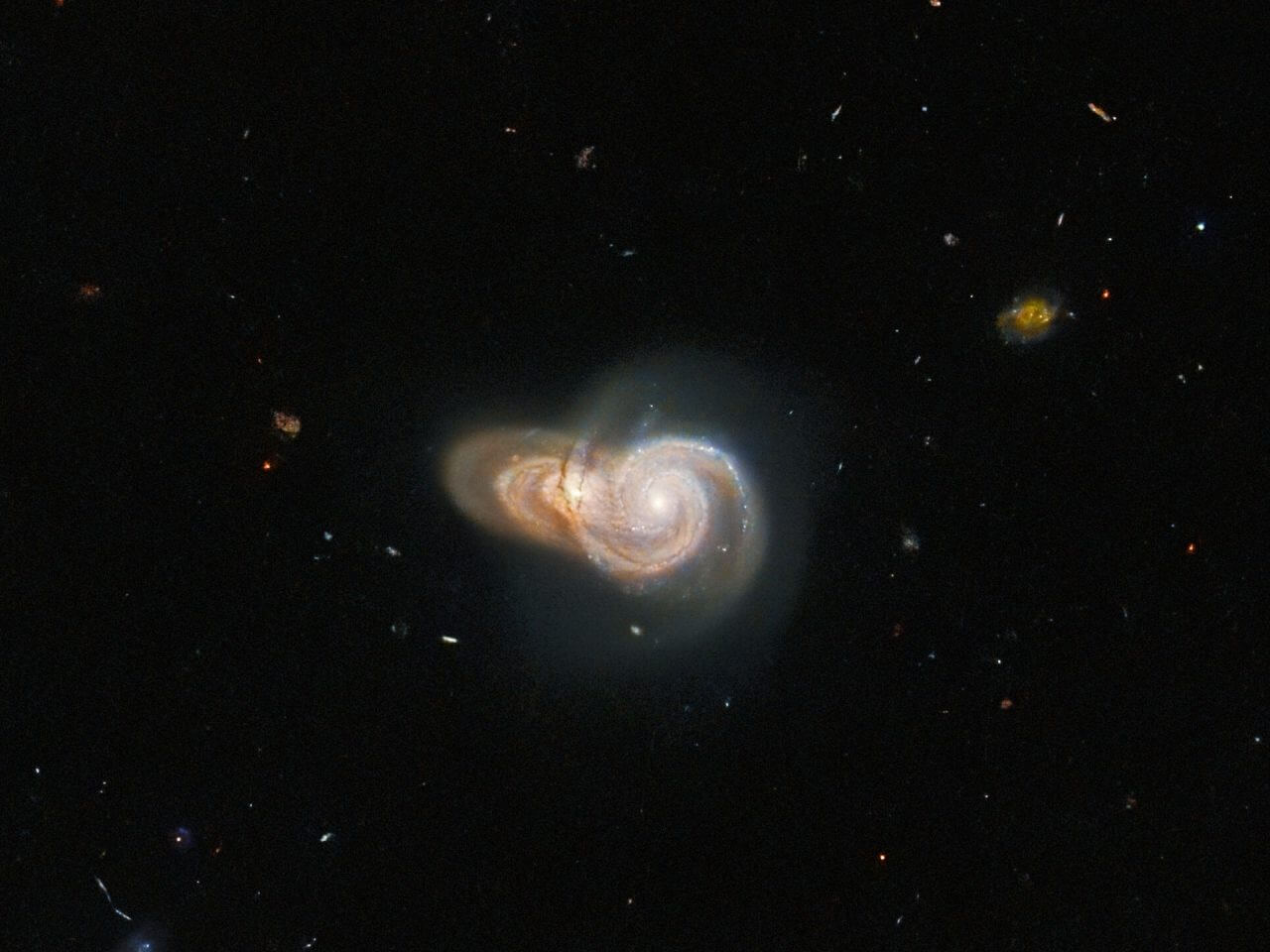 【▲ 重なり合う2つの銀河「SDSS J115331」（左）と「LEDA 2073461」（右）。公開された画像の中央付近を拡大したもの（Credit: ESA/Hubble and NASA, W. Keel）】