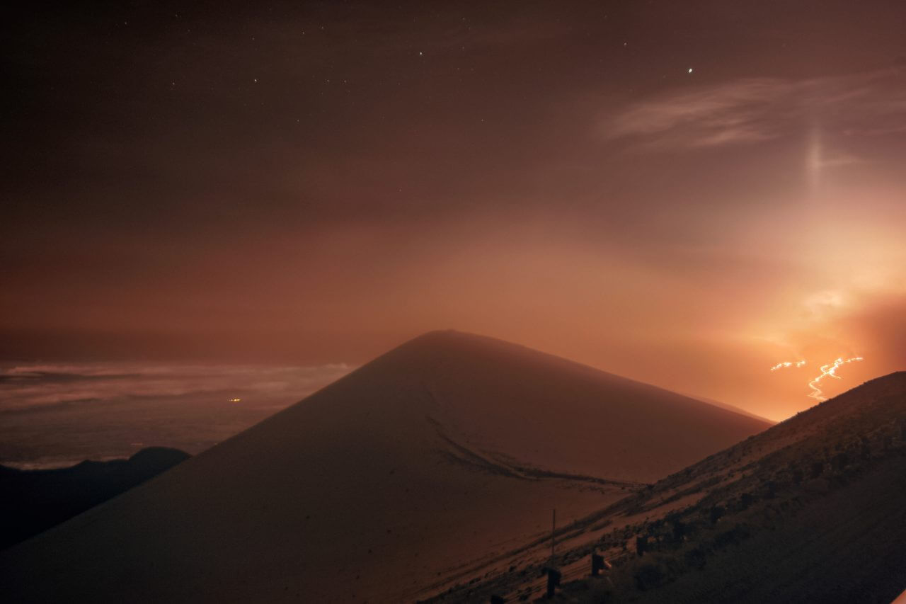 【▲ マウナケア山のジェミニ天文台で撮影されたマウナロア山の溶岩流（右奥）（Credit: International Gemini Observatory/NOIRLab/NSF/AURA）】