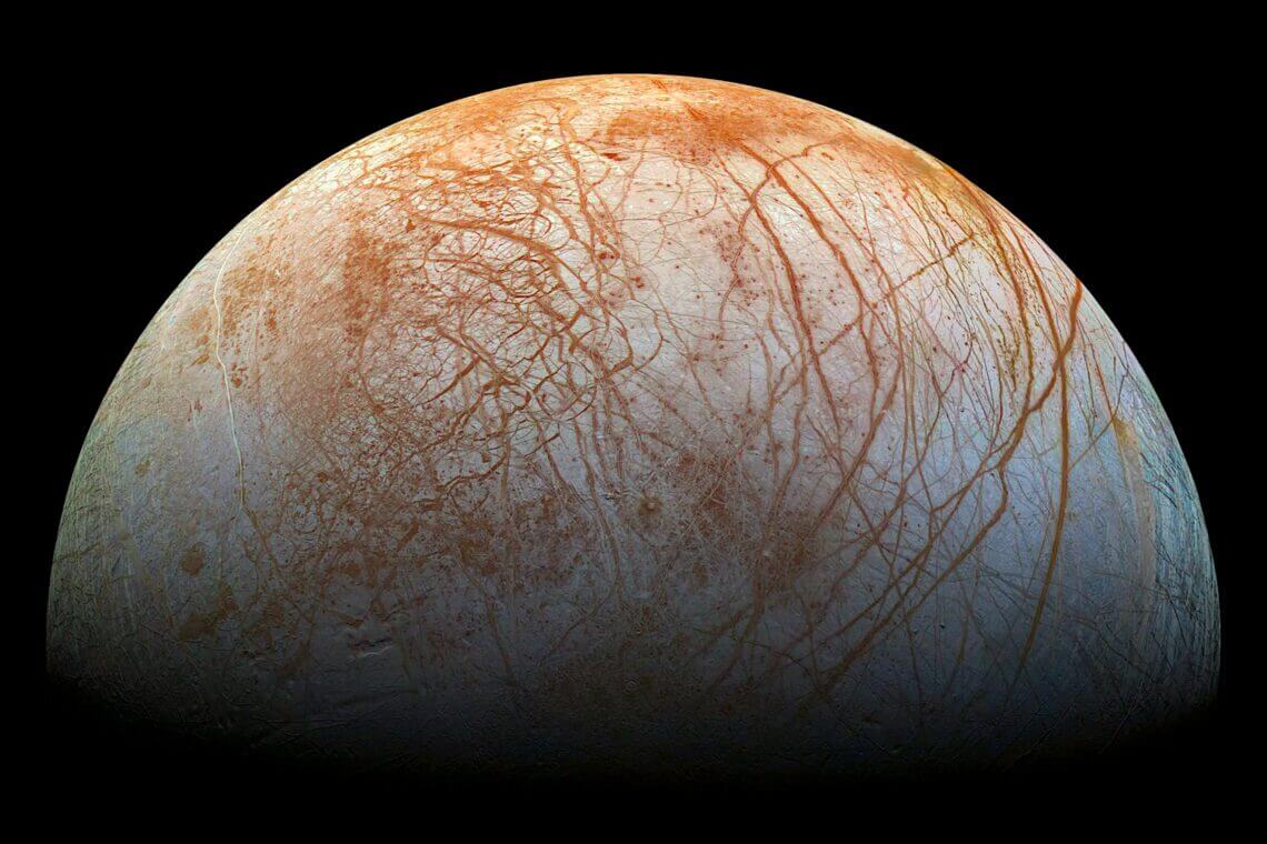 【▲ 図1: エウロパの表面には無数の筋があり、色がついて見える。これは地下から運ばれた様々な物質に由来すると見られている。そしてスペクトルデータでは塩化ナトリウム水和物の存在を示唆しているものの、対応する物質が見つかっていないという問題があった。 (Image Credit: NASA/JPL/Galileo) 】