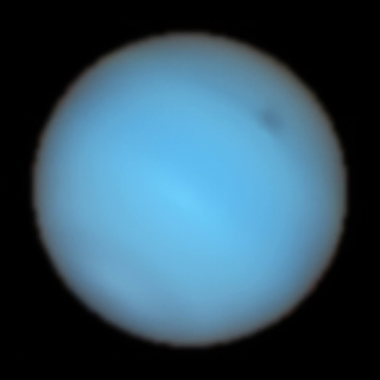 【▲ 図3: VLTのMUSEで2019年に撮影された海王星の画像。右上にある薄暗い反転が暗斑のNDS-2018である。今回の観測で、地上の望遠鏡で初めて撮影された暗斑となった。 (Image Credit: ESO, P. Irwin et al.) 】