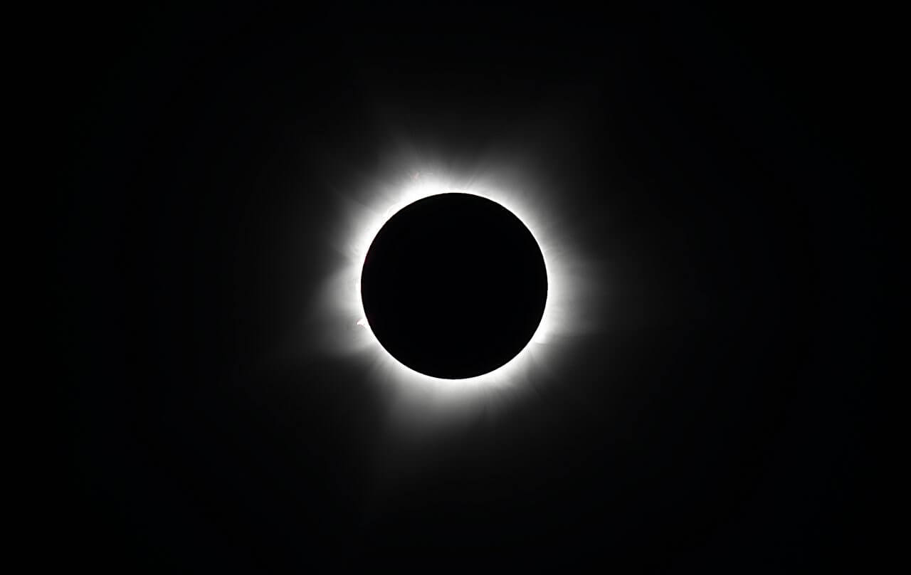 【▲ 図: 2023年4月20日にオーストラリアのエクスマウスで観測された皆既日食。黒い太陽の影の周りに見られる白い環がコロナ。 (Image Credit: Mantarays Ningaloo, Australia/MIT-NASA Eclipse Expedition) 】