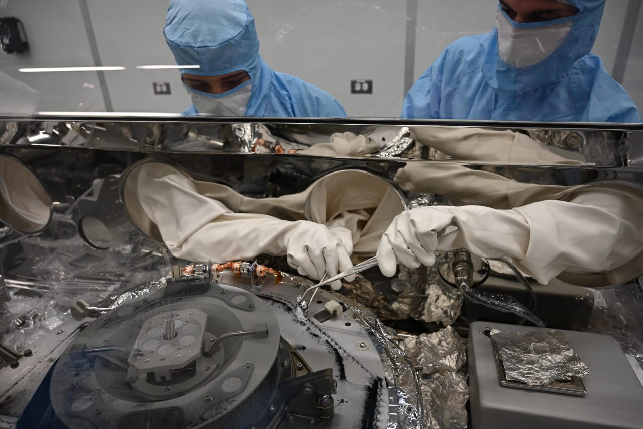 【▲ ジョンソン宇宙センターの専用クリーンルームに設置されたグローブボックスでベンヌのダスト（塵）を収集する様子。2023年9月27日撮影（Credit: NASA）】