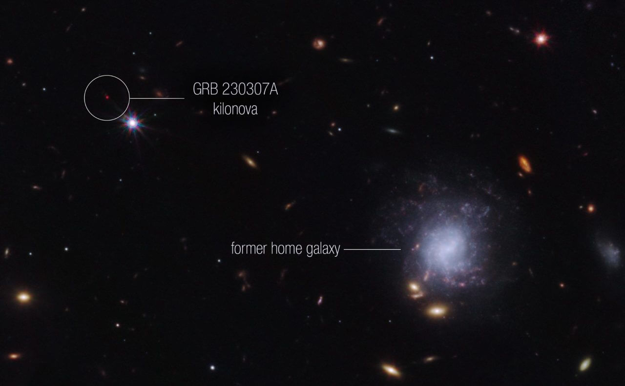 【▲図1: 左上の赤い点がGRB 230307A。右下の渦巻銀河は、GRB 230307Aの元となった中性子星の連星が元々属していた銀河。お互いの距離は約12万光年離れている。 (Image Credit: NASA, ESA, CSA, STScI & Andrew Levan (IMAPP, Warw) ) 】