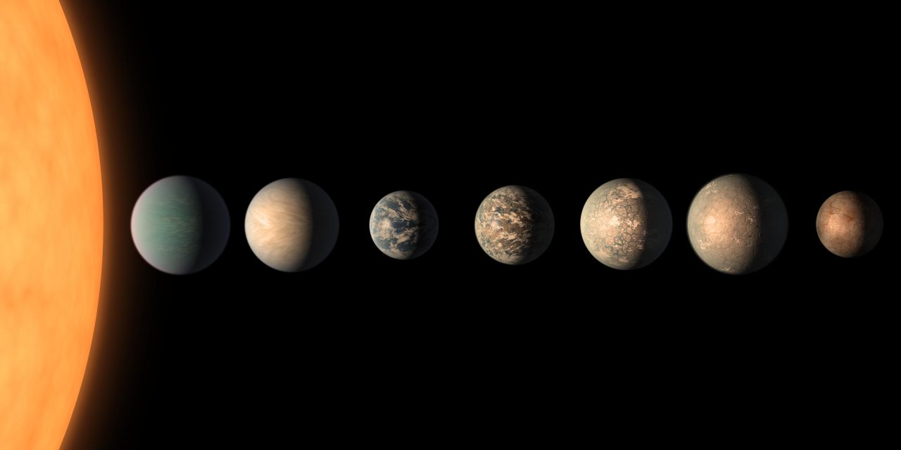 赤色矮星「TRAPPIST-1（トラピスト 1）」（左端）を公転する7つの太陽系外惑星の想像図