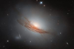 結ぶように渦巻く塵の帯　ハッブル宇宙望遠鏡が観測したレンズ状銀河「NGC 7722」