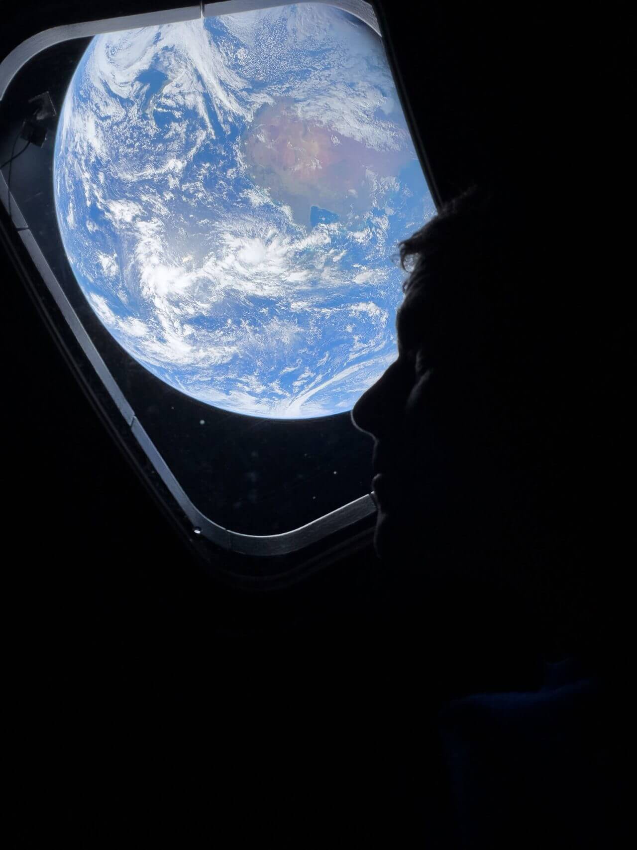 月へ向かう軌道に乗ったOrion宇宙船の窓から地球を眺めるNASAのReid Wiseman宇宙飛行士（Credit: NASA）