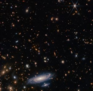 ウェッブ宇宙望遠鏡が観測した渦巻銀河「LEDA 2046648」と背後で輝く無数の銀河