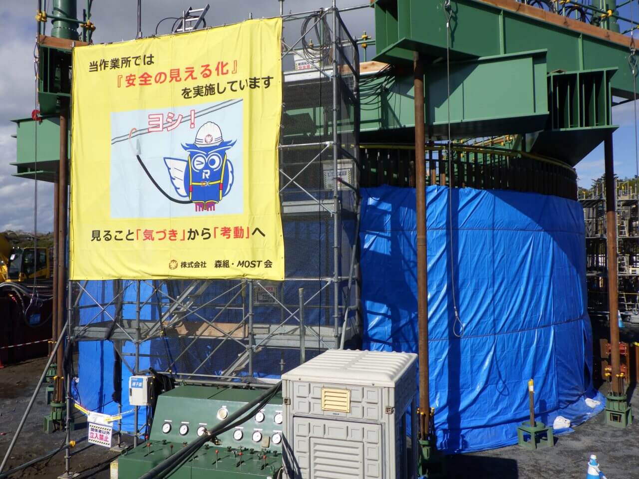 図4: 油圧装置の上に昇るための足場と比較すれば、刃口だけで高さが4m以上あることが実感できます。（Credit: 彩恵りり）