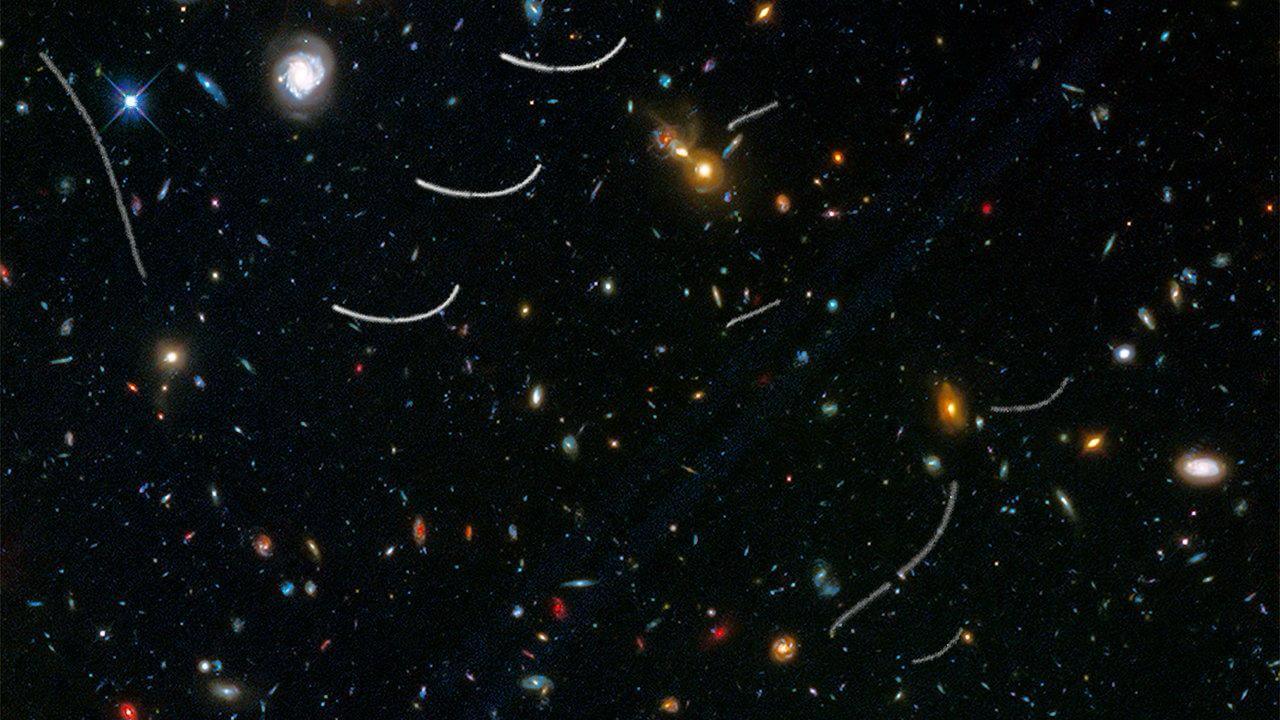 遠方銀河に重なって見える多数の小惑星の軌跡