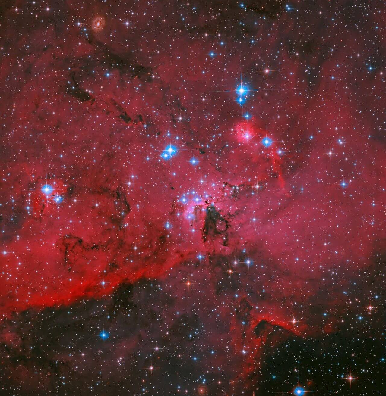 赤と青のコントラストが美しい領域 ハッブル宇宙望遠鏡が観測した星形成領域「LH 95」